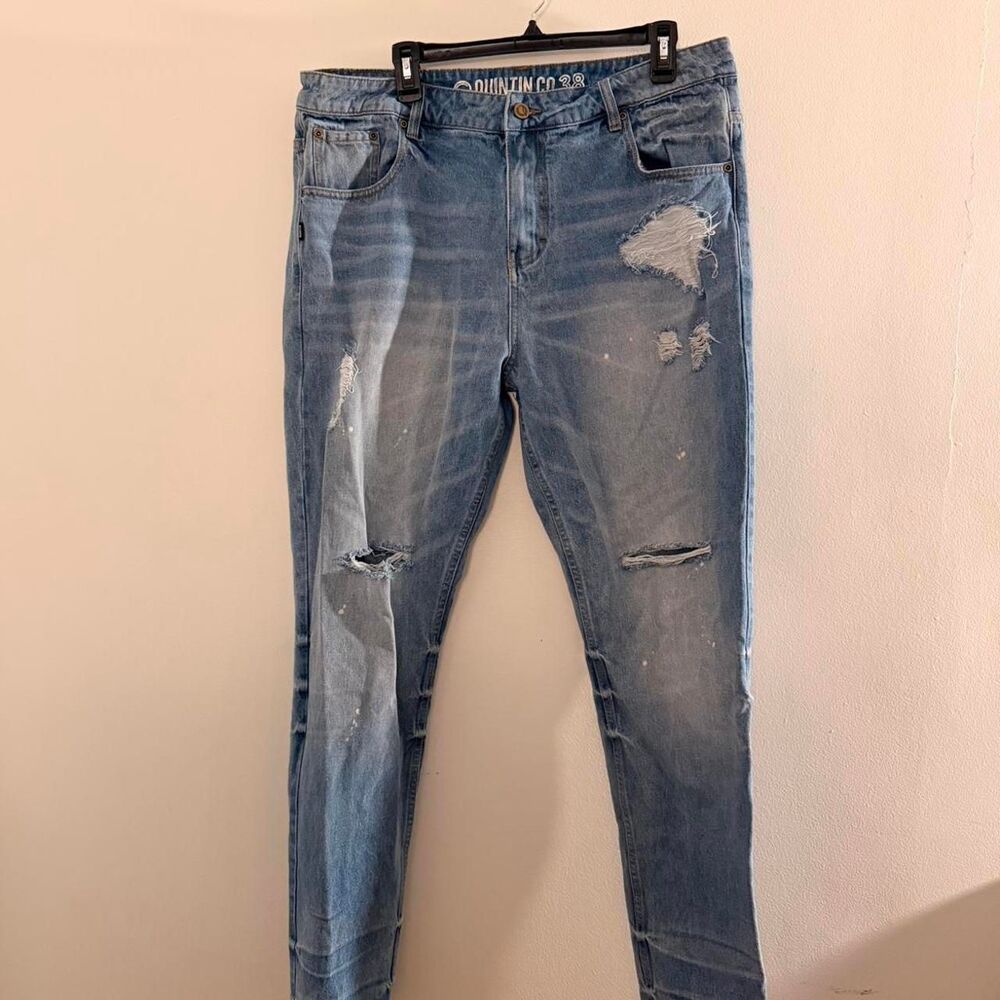 Quintin Co distressed blue denim jeans with a relaxed fit and paint splatter det